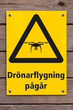 Varningsskylt på trävägg, Drönarflygning