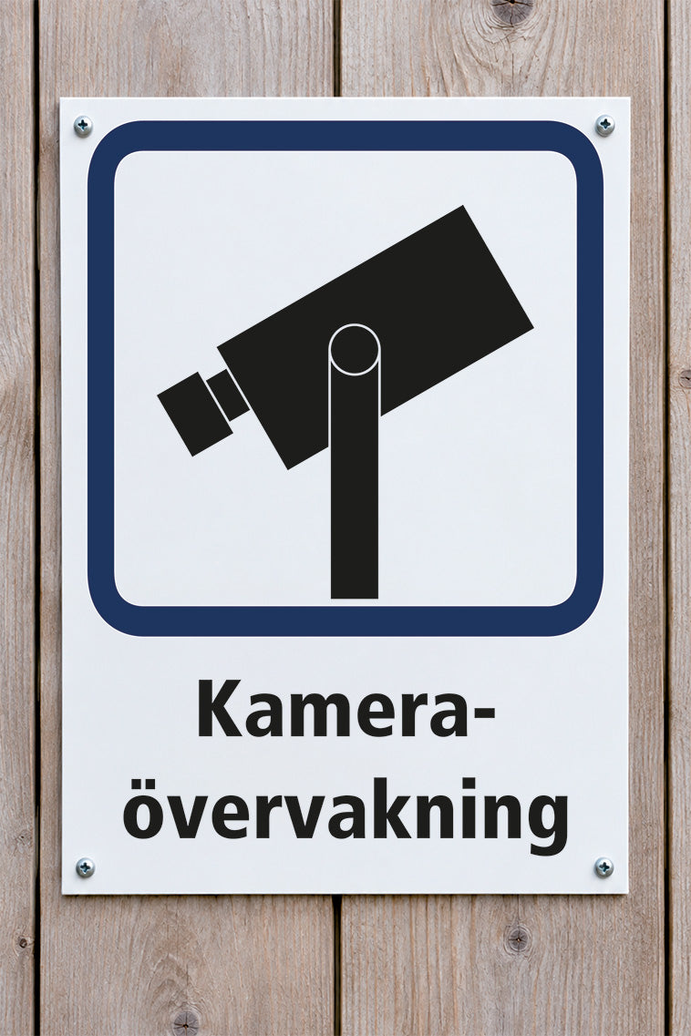 Infoskylt på trävägg - Kameraövervakning